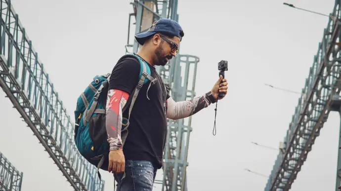 a man with a backpack and a backpack walking on a bridge
